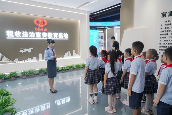 9月13日，在渝北區稅收法治宣傳教育基地，稅務人員給渝北區數據谷小學的同學們講解稅收發展史。紀源攝