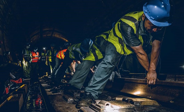 齊心協力抬鐵軌。田芝銘攝