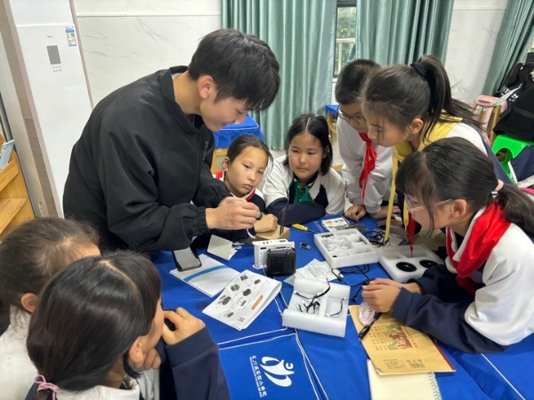 重慶文理學院人工智能學院的“X導師”帶領項目組學生組裝小汽車。永川區實驗小學供圖