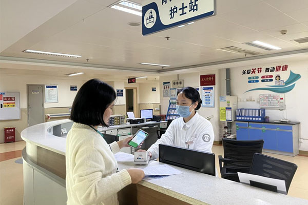 患者家屬在骨關節外科護士站辦理出院結算手續。重慶大學附屬江津醫院供圖