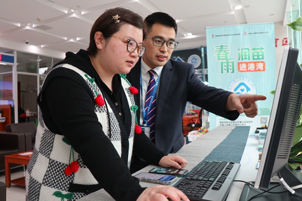 在三峽銀行綦江支行銀行，工作人員輔導市民韓女士網上申報納稅。李奕萱攝