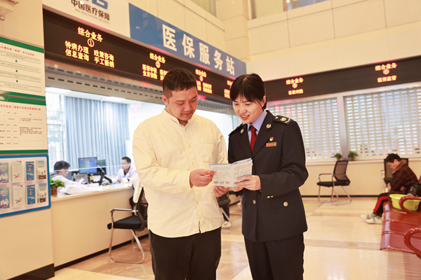 在重慶市第九人民醫院“醫保服務站”，稅務人員正向繳費人宣傳講解醫保繳費政策。楊蔓攝