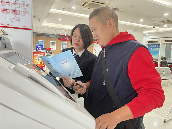重慶農商行大渡口支行鋼花分理處大堂經理通過宣傳折頁對客戶講解反詐知識。重慶農商行供圖