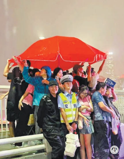 重慶市公安局江北區分局交巡警支隊輔警夏英柯在執勤中偶遇暴雨，與市民、游客一同避雨。重慶市公安局江北區分局供圖