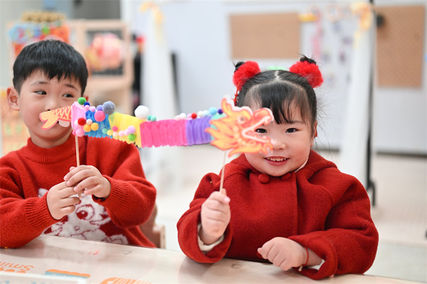 小朋友展示制作的手工翻花龍。郭旭攝