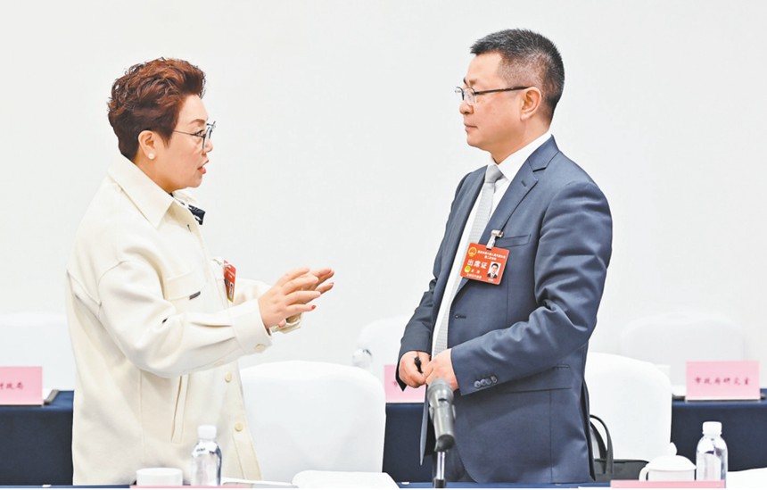 　1月22日，市人大代表在會議間隙就引進AI機器人智能駕培系統的建議展開討論。記者 齊嵐森 攝/視覺重慶