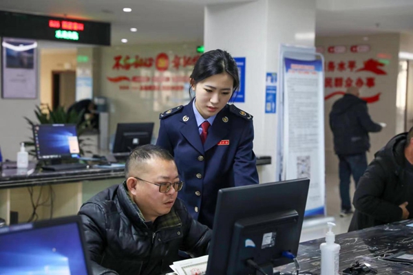 在梁平區辦稅服務廳電子稅務局辦理專區，稅務人員輔導企業辦稅人員線上辦稅。唐曉敏攝