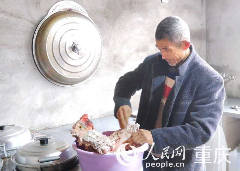 佘中華在新家廚房制作腌肉。人民網 陳琦攝