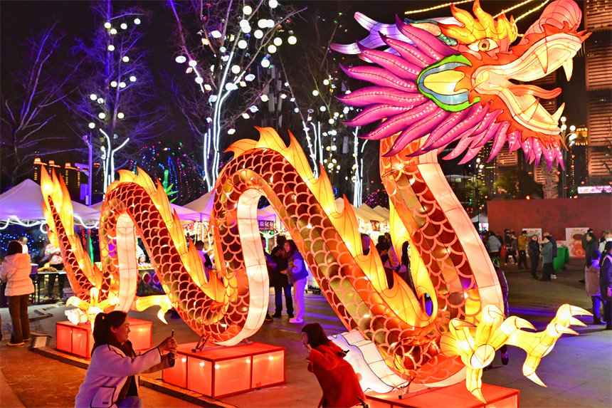 游客在南岸區南濱路鐘樓廣場賞燈拍照。郭旭攝