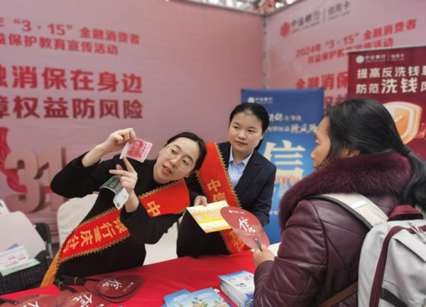 工作人員向消費者講解如何識別假幣。中信銀行重慶分行供圖