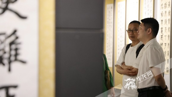 書畫展觀眾認真觀賞作品。華龍網記者 李燊 攝