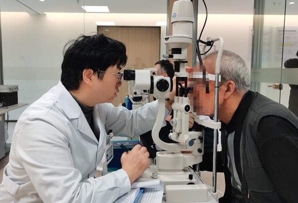 張曉城為患者檢查術后視力情況。重慶南坪愛爾眼科醫院供圖