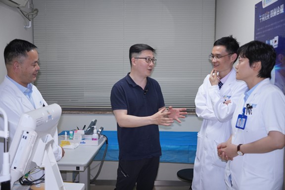 何勇（左二）與醫生探討科AI的應用。重慶普瑞眼科醫院供圖