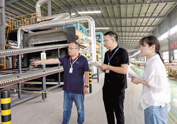 工作人員在企業生產車間，走訪了解企業發展情況。華鎣市融媒體中心供圖