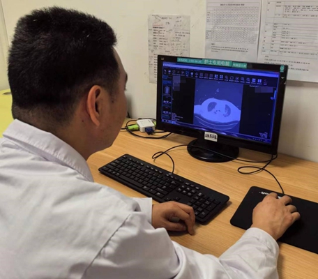 王曉龍查看患者的肺部CT檢查結果。重慶醫科大學附屬第二醫院供圖