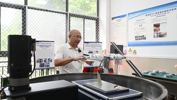 在重慶大學機械傳動國家重點實驗室，教授陳兵奎正介紹夢天實驗艙阿爾法對日定向驅動機構對構齒輪傳動。重慶大學供圖