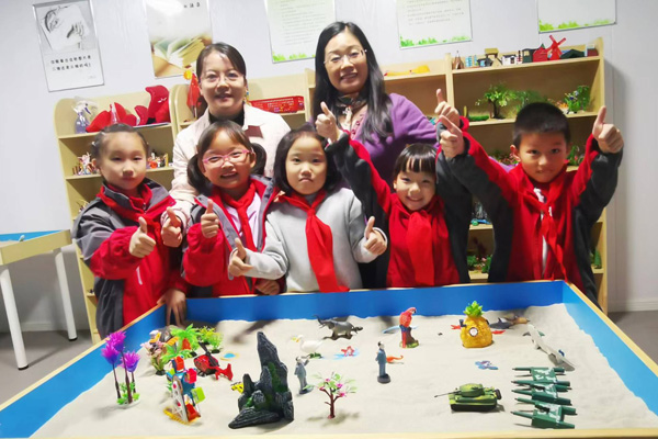 楊雪梅書記（左一）指導學生參與心理沙盤體驗活動。四牌坊小學供圖