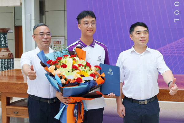 陳睿（中）拿到錄取通知書。李聰沖攝