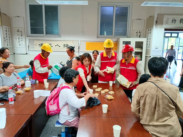 國家電網紅巖（榮昌）共產黨員服務隊隊員在吳家鎮中心小學應急安置點向群眾發放慰問食品。國網重慶永川供電公司供圖