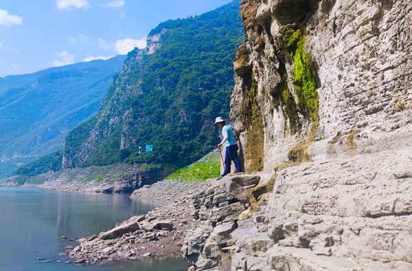 《行走于懸崖峭壁間》。2023年7月，涪陵烏江邊，南江地質隊駐守工程師田正熙小心翼翼行走在懸崖峭壁間，調查烏江沿線巖體劣化和地質災害情況。向棋攝