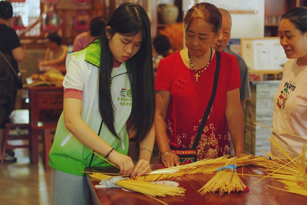 草編匠人教團隊成員編織草帽。張好攝
