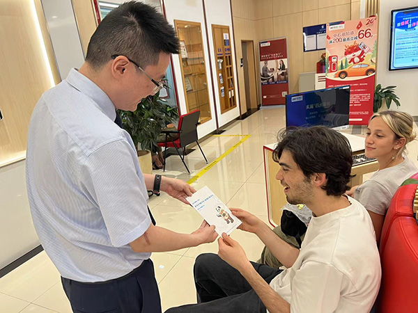 為外籍來華人員發放雙語宣傳折頁。浦發銀行重慶分行供圖