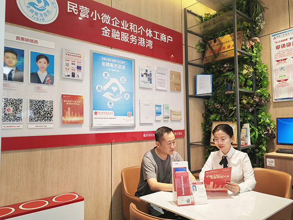 重慶農商行江北支行鳳瀾路金融服務港灣客戶經理為客戶講解貸款產品相關政策。重慶農商行供圖