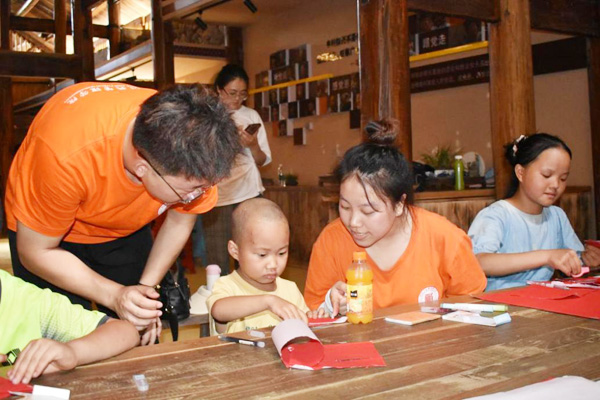 實踐團成員指導當地兒童剪紙。西南政法大學供圖