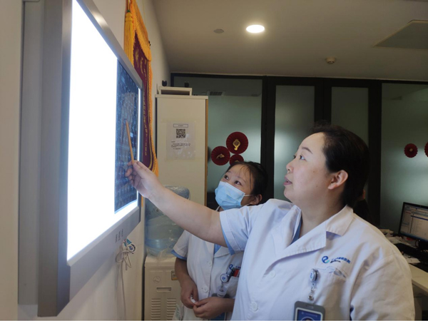 張朝梅查看患者的檢查報告。重慶仁品耳鼻喉醫院供圖