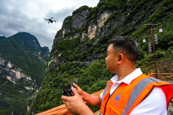 《科技巡查 排除險患》。7月5日，巫溪縣蘭英鄉掛壁天路，地災駐守單位重慶一三六地質隊隊員使用無人機進行排查工作。尹詩語攝