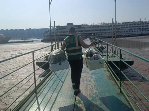 配送人員肩挑果蔬，忙著給各個單位送貨。豐都實業供圖。