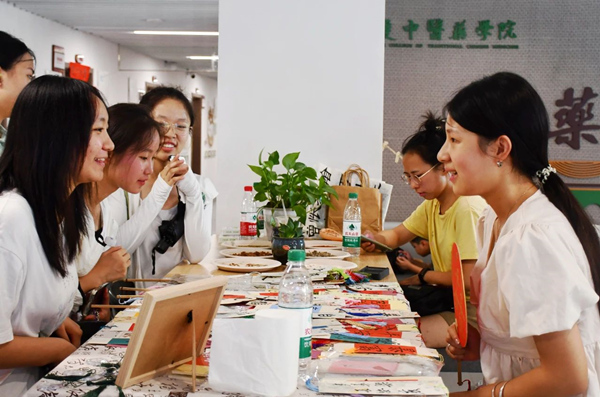 中藥學院迎新現場，新生和家長們對各種中草藥文創產品興趣濃厚。重慶中醫藥學院供圖