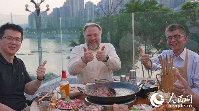 康寧顯示科技事業部全球拓建項目總監軻寶華（中）和同事在重慶南濱路吃火鍋。人民網記者 蘇纓翔攝