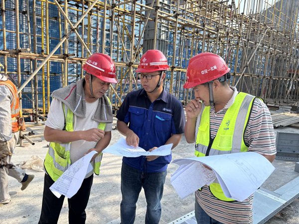 在萬州上海醫院新院區施工現場，施工人員在認真討論。中交一公局三公司供圖
