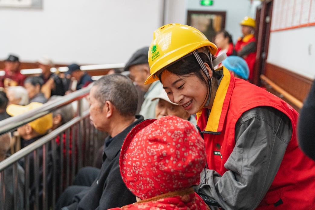 國家電網紅巖（永川）山城青電青年突擊隊隊員與老人們親切交談。國網重慶永川供電公司供圖