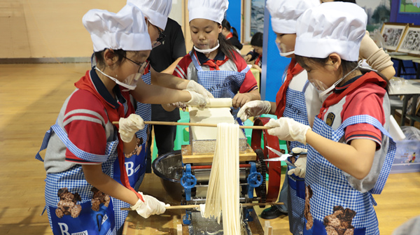 展評活動現場，學生用壓面機制作面條。重慶市萬盛經開區教育局供圖