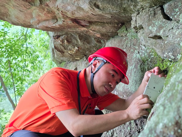 《專注》。7月3日，南江地質隊地質工程師陳昊在開州區麻柳鄉調查危巖。劉黎攝