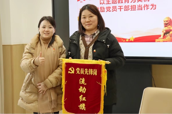 紅星幼兒園黨支部書記、園長牟小莉向黨員先鋒崗頒發流動紅旗。紅星幼兒園供圖
