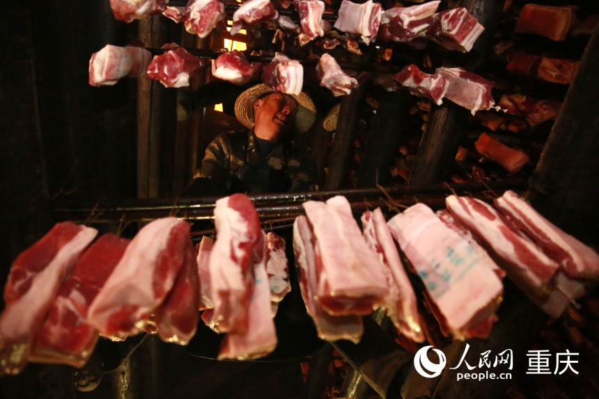 工人將腌制好的豬肉掛入炕房。人民網記者 劉政寧攝