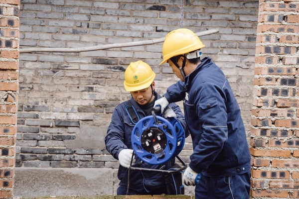 電力人員檢查供電線路并牽線入戶。國網重慶永川供電公司供圖