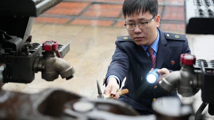 中歐班列發車前，謝嗣航正在對機車走行部關鍵部件進行檢查。周彥超攝