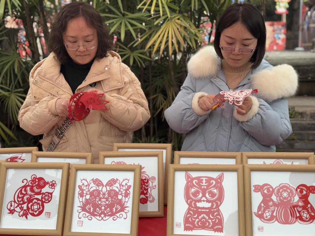 袁誼、趙俊教孩子們剪紙。黃亞輝攝