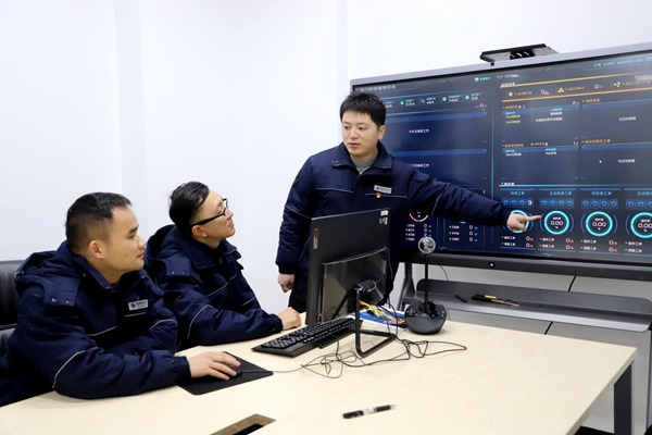 程政（右一）與同事研討電力大數據問題。國網永川供電公司供圖