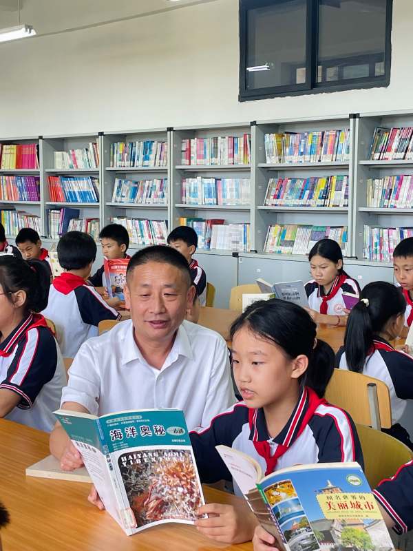 顏林在閱覽室與學生閱讀。梁平區委宣傳部供圖