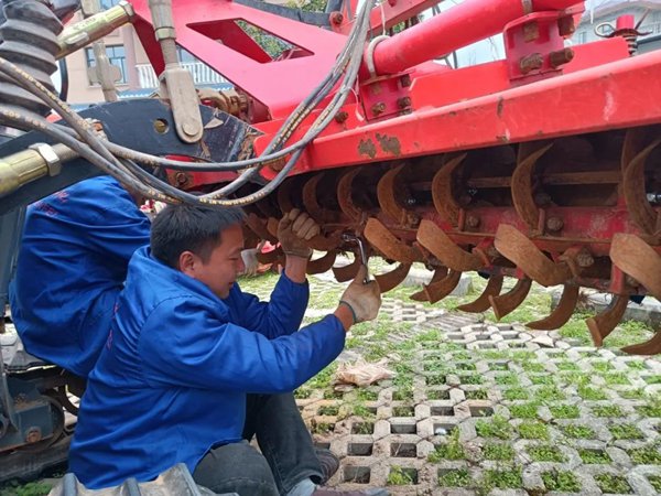 農服墊江公司農機手檢修旋耕機。重慶智慧農服集團供圖