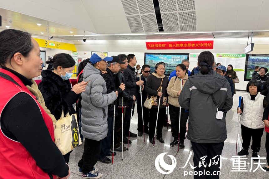 現場軌道交通工作人員為盲人朋友介紹便利設施。人民網記者 胡虹攝