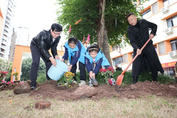 學生和老師、家長攜手植綠，共同美化校園。秦廷富攝