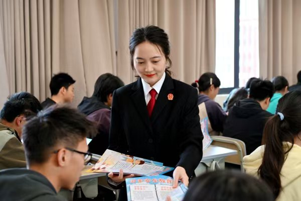 向學生們發放宣傳資料。主辦方供圖