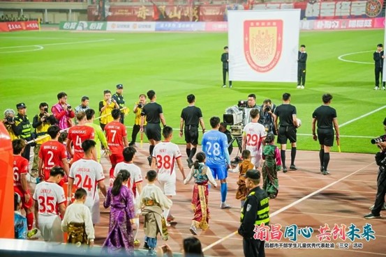 銅梁龍隊員與昌都孩子攜手入場。重慶銅梁龍足球俱樂部供圖