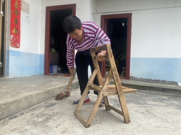 蔡其蘭用板凳撐著打掃衛生。黃河攝